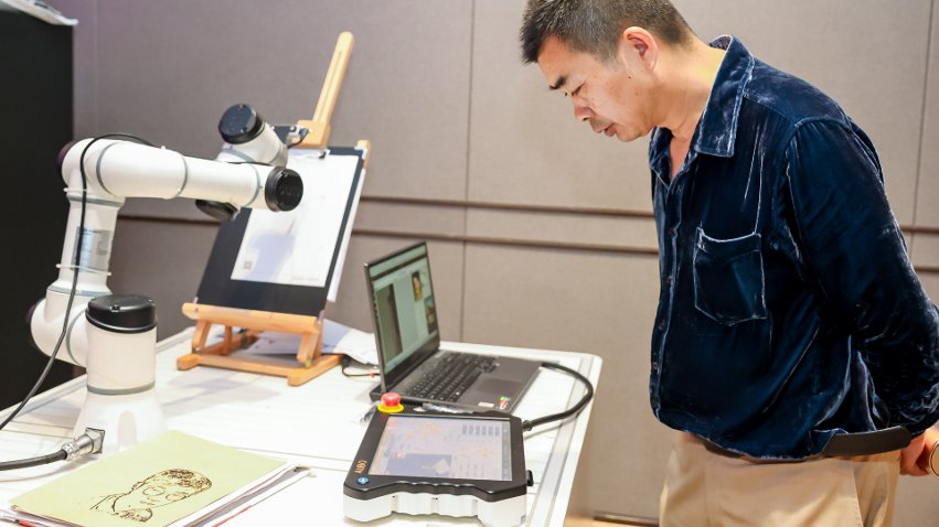 嘉賓體驗(yàn)遨博AI繪畫機(jī)器人。主辦方供圖